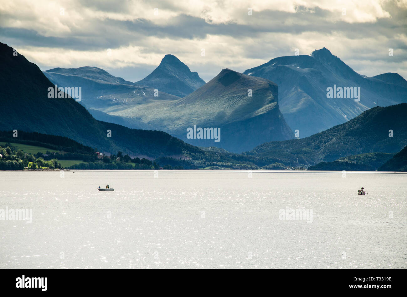 Vista magica di due barche a vela su un fiordo norvegese con le montagne alle spalle e cielo molto nuvoloso Foto Stock