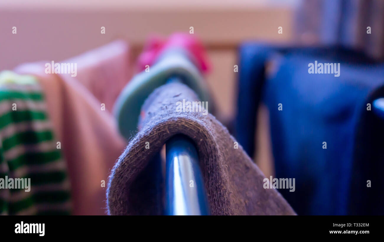 Close up di calza essiccazione su un rack, diurno. Raffigurante il giorno di Lavanderia, Pulizia casa e manca il calzino coppie. Foto Stock