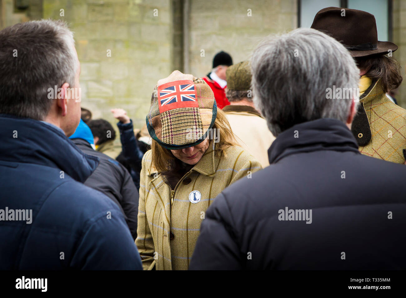 Signora in una folla di persone che indossano Unione Jack cap al vecchio Burstow Surrey e West Kent caccia al Chiddingstone Castle per il Boxing Day si incontrano in Kent, Regno Unito Foto Stock