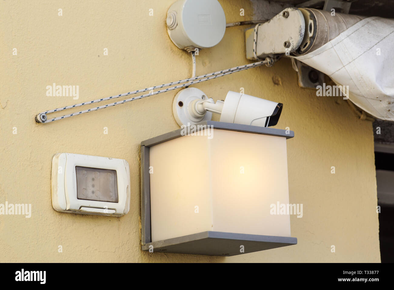 Moderno telecamera TVCC su una parete. Una notte sfocata cityscape sfondo. Concetto di sorveglianza e monitoraggio. Tonica immagine doppia esposizione mock up Foto Stock