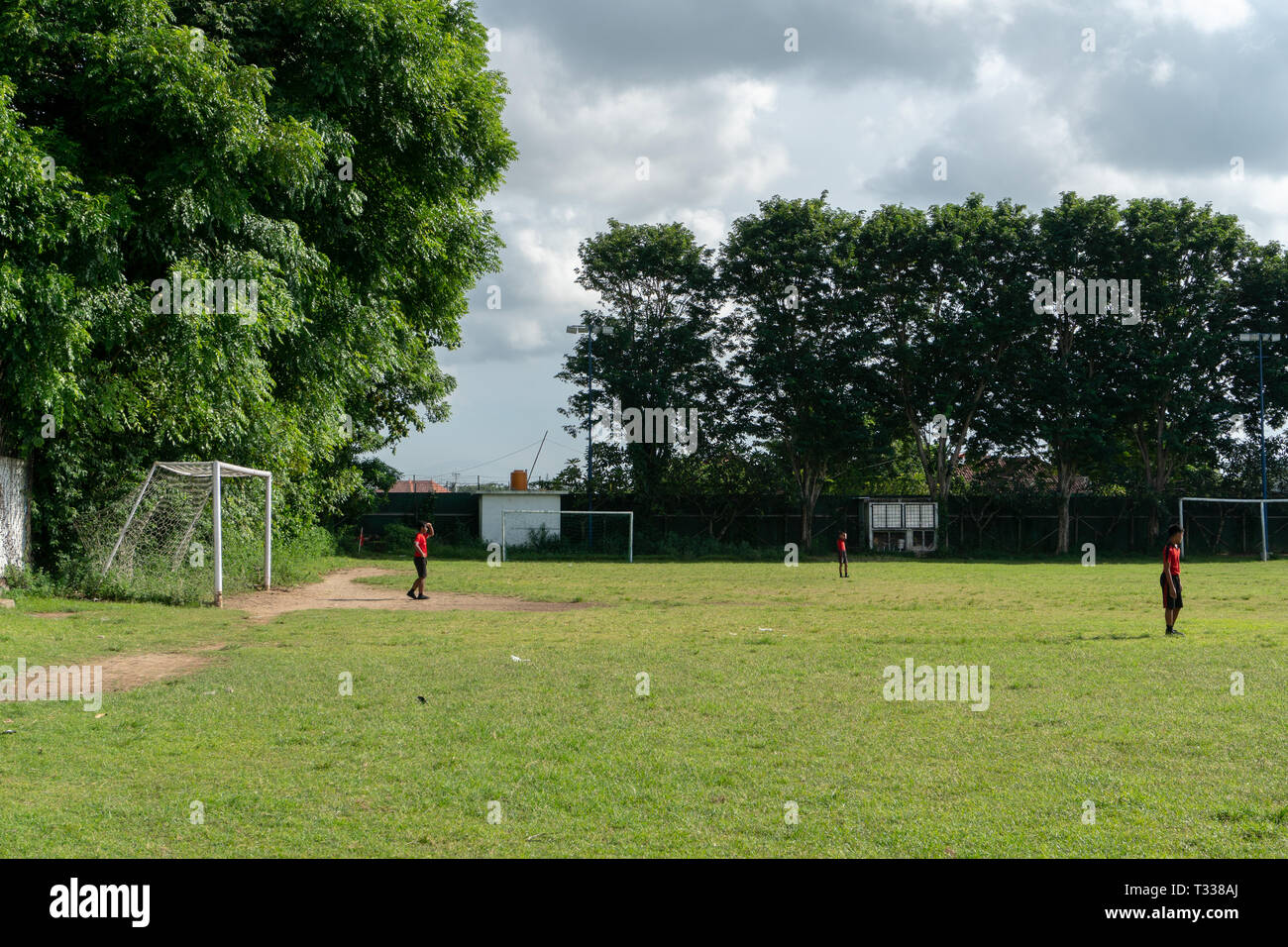 BADUNG,BALI/INDONESIA-aprile 05 2019: Elementare studente in Bali giocare a calcio o di calcio sul campo con maglia rossa. Foto Stock