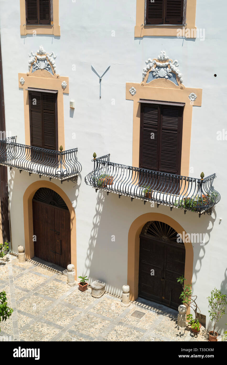 Tipica siciliana di Palazzo cortile e architetture riccamente ornate con ghisa balcone e la vecchia pavimentazione in pietra nella città di Palermo, Sicilia, Italia Foto Stock Tipica siciliana di Palazzo cortile e architetture riccamente ornate con ghisa balcone e la vecchia pavimentazione in pietra nella città di Palermo, Sicilia, Italia Foto Stock