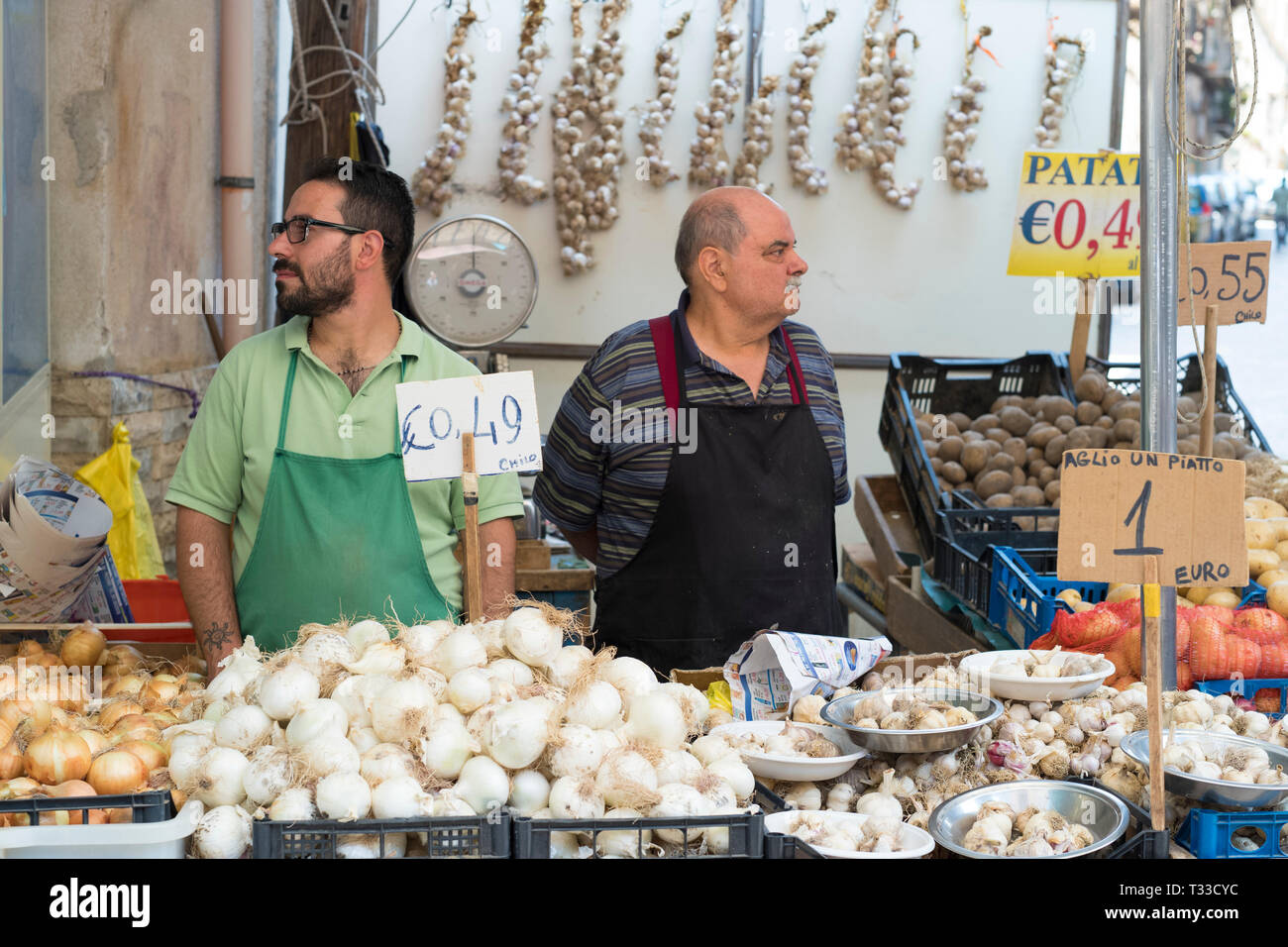 Vendita Stallholders cipolle, aglio, patate al famoso Ballero street market per le verdure e il cibo fresco, Palermo, Sicilia, Italia Foto Stock