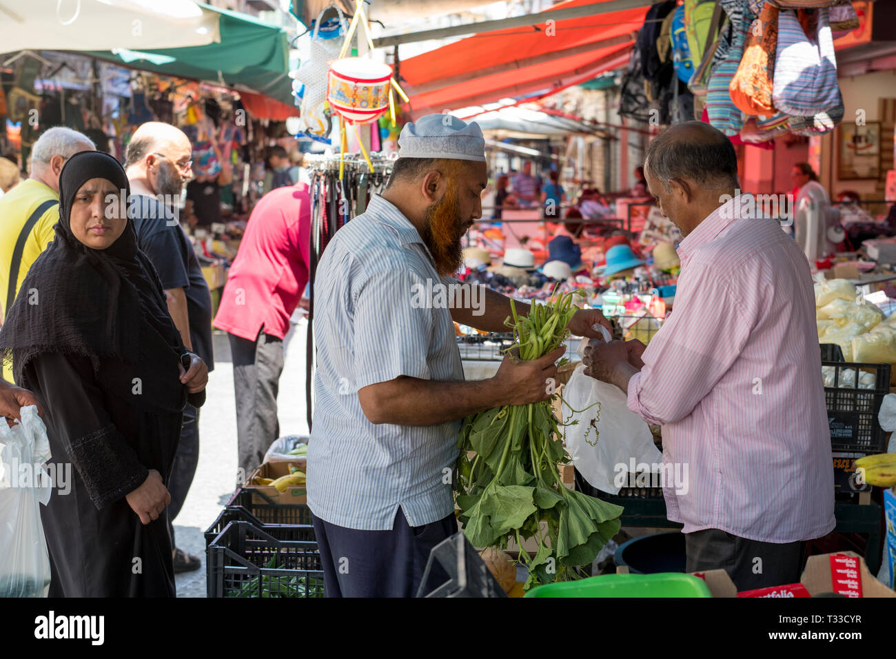 Coppia musulmana sono i clienti presso il famoso Ballero street market per le verdure e altri cibi freschi a Palermo, Sicilia, Italia Foto Stock