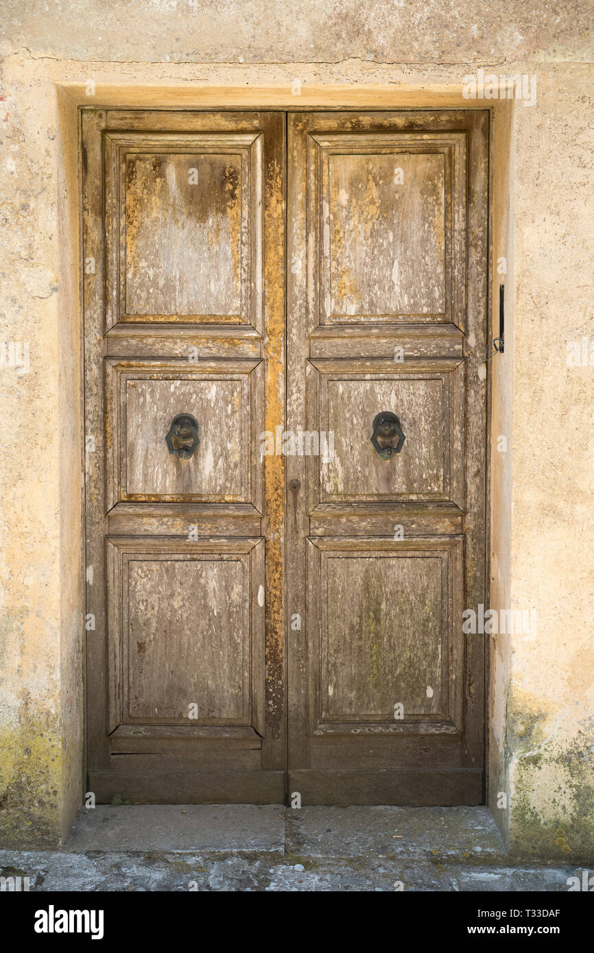 Caratteristico vecchio dalle intemperie in legno porta doppia e porta nel centro storico di Erice, in Sicilia, Italia Foto Stock