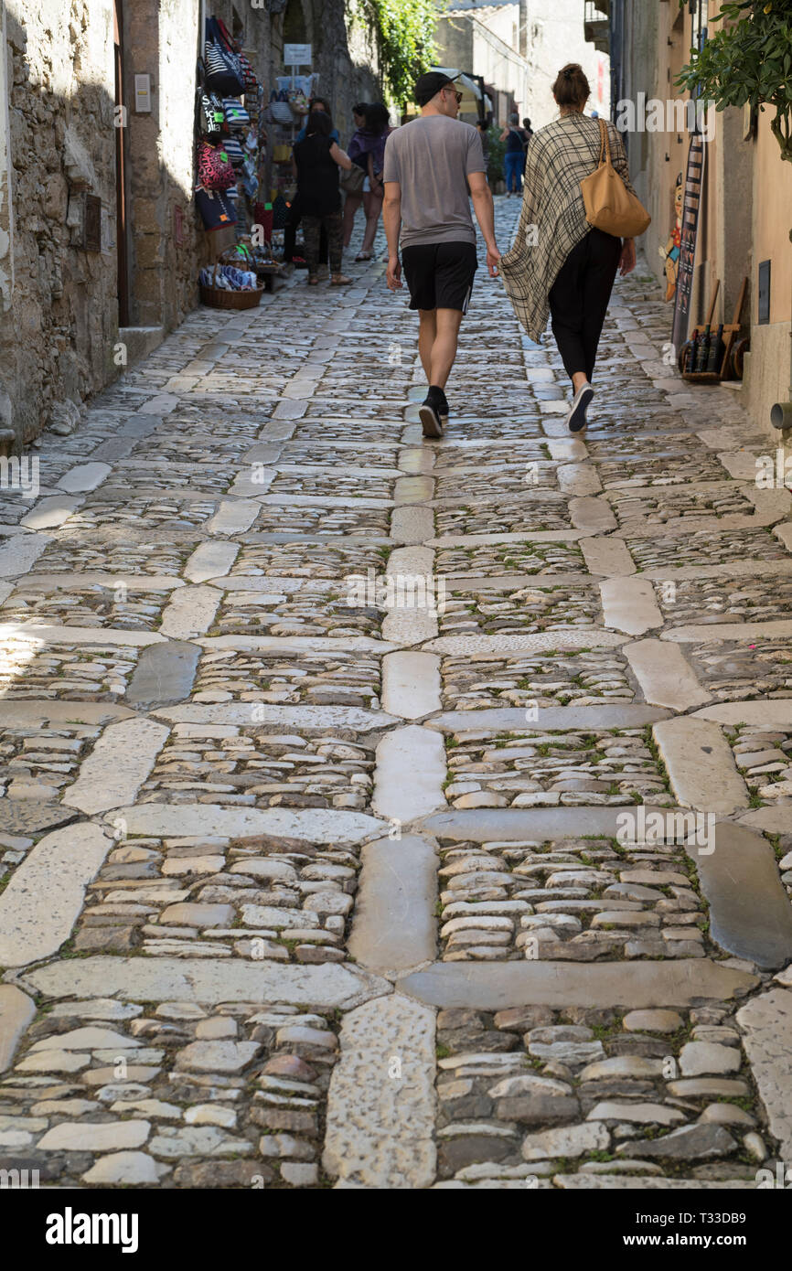 Scena di strada di Vista posteriore della coppia giovane in ciottoli vicolo di via Chiesamonte, Erice, in Sicilia, Italia Foto Stock