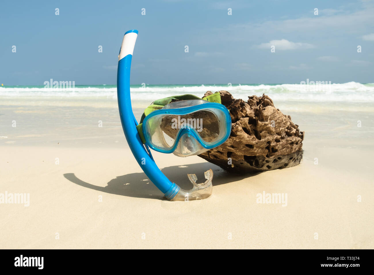 Maschera e snorkel nel surf sulla spiaggia sabbiosa di messa a fuoco selettiva. Foto Stock