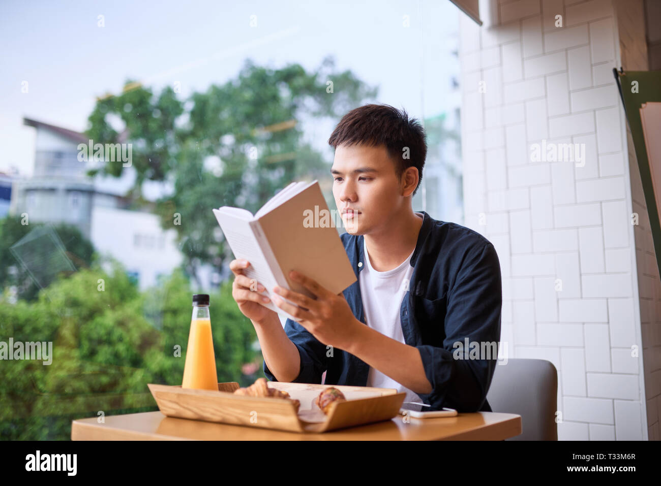 Gli uomini la lettura di un libro sul tempo di tè Foto Stock