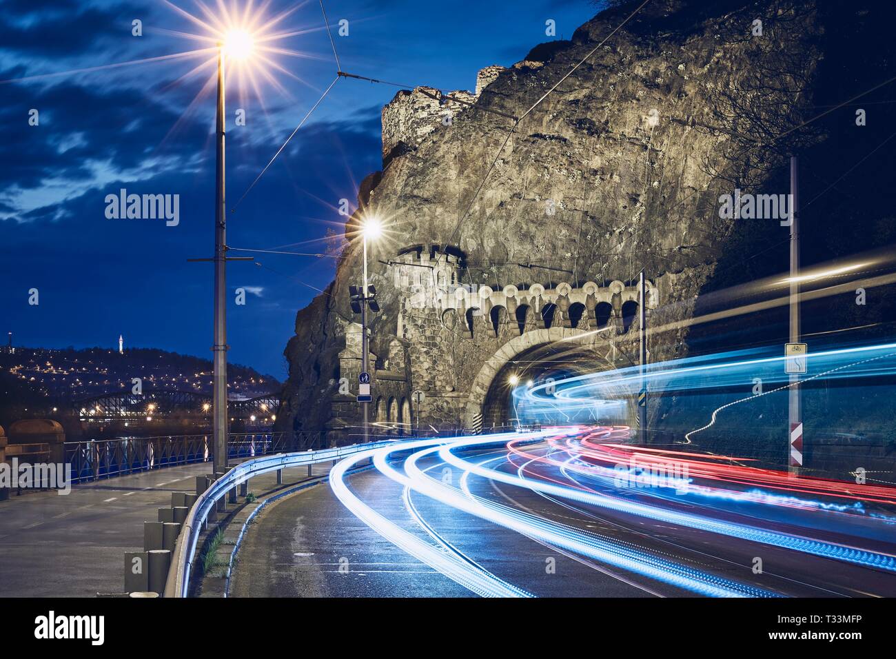 Il traffico notturno in città. Sentieri di luce di tram e auto sulla strada per tunnel di Vysehrad. Praga, Repubblica Ceca Foto Stock