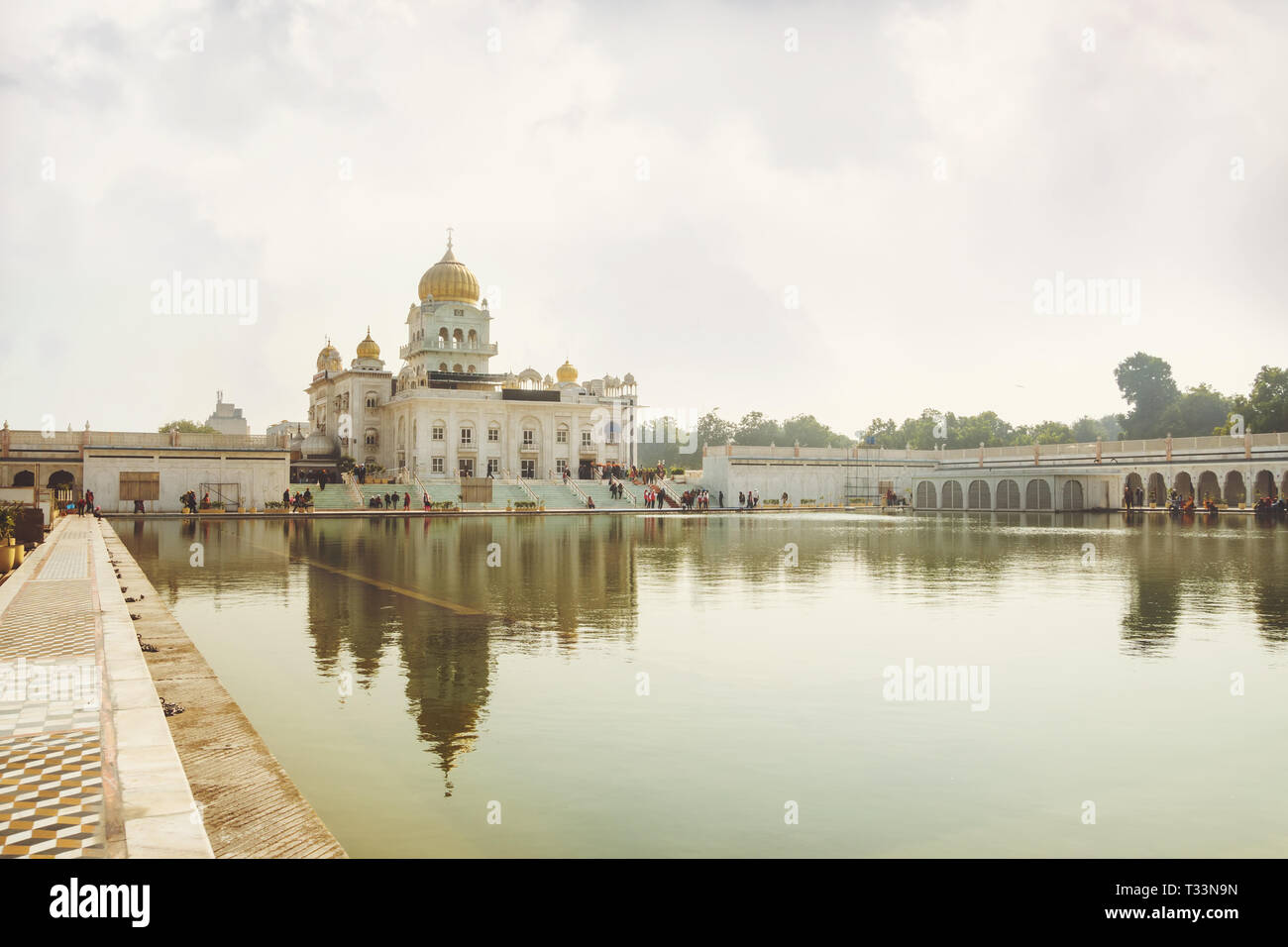 Gurdwara Bangla Sahib è il più prominente Gurdwara Sikh. Un luogo sacro della religione sikhi. Cupola dorata del tempio di colore giallo brillante sun. Una lar Foto Stock