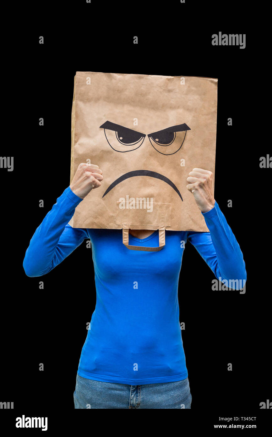 Donna indossa sacchetto di carta con volto arrabbiato isolati su sfondo nero Foto Stock