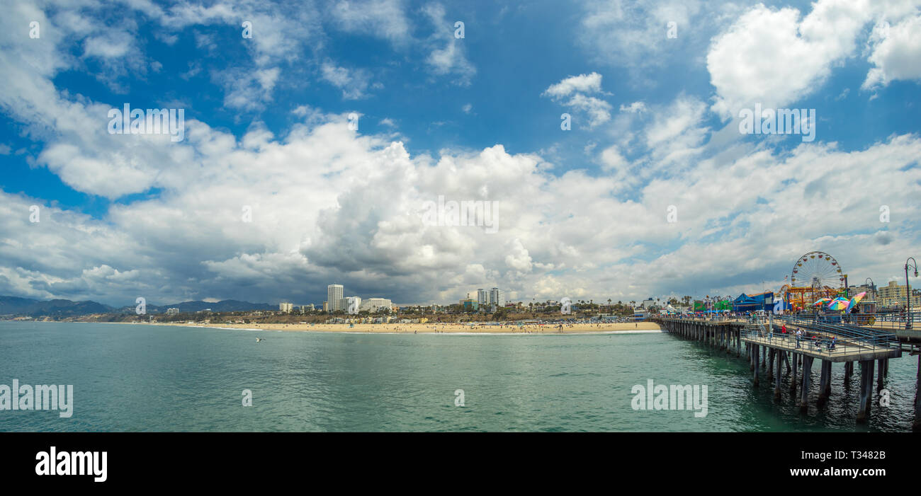 La spiaggia di Santa Monica e il famoso molo sulla giornata soleggiata con cielo blu e il cloud, ampio angolo di panorama Foto Stock