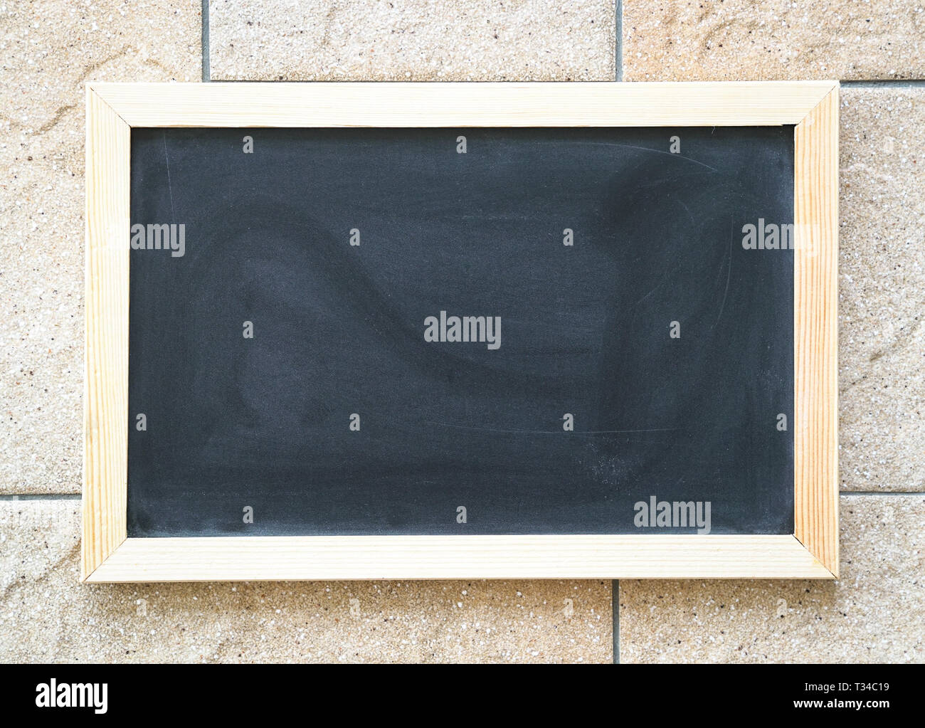 Vuoto Utilizzato blackboard sul colore beige parete piastrellata, concetto di sfondo Foto Stock