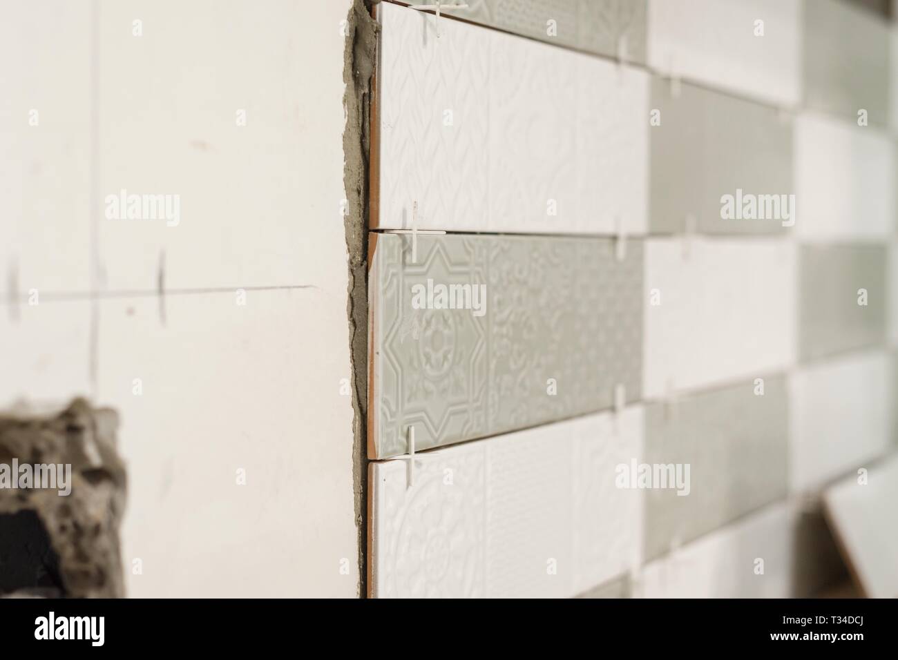 Procedimento per la posa di piastrelle di ceramica, la costruzione e la riparazione in cucina, piastrelle. Foto Stock