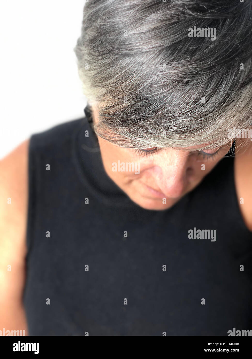 Ritratto di una donna con i capelli grigi guardando verso il basso Foto Stock