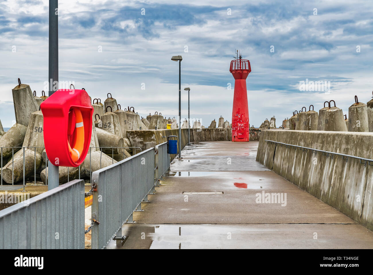 Il faro rosso è un cosiddetto pier luce e segna l'entrata al porto di Kolobrzeg, West Pomerania, Polonia, Europa Foto Stock
