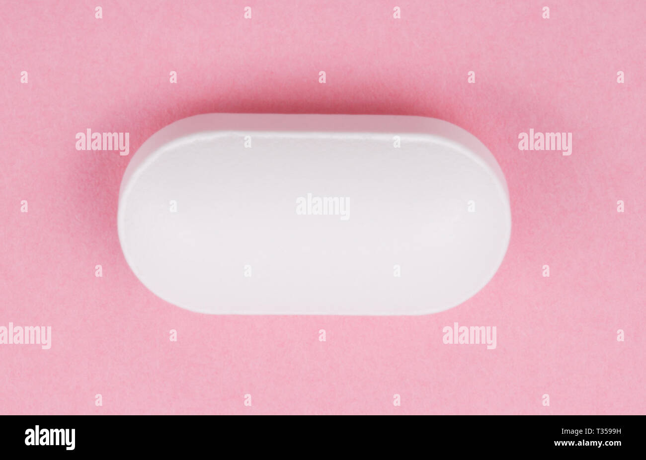 Pillola bianco su sfondo rosa Foto Stock