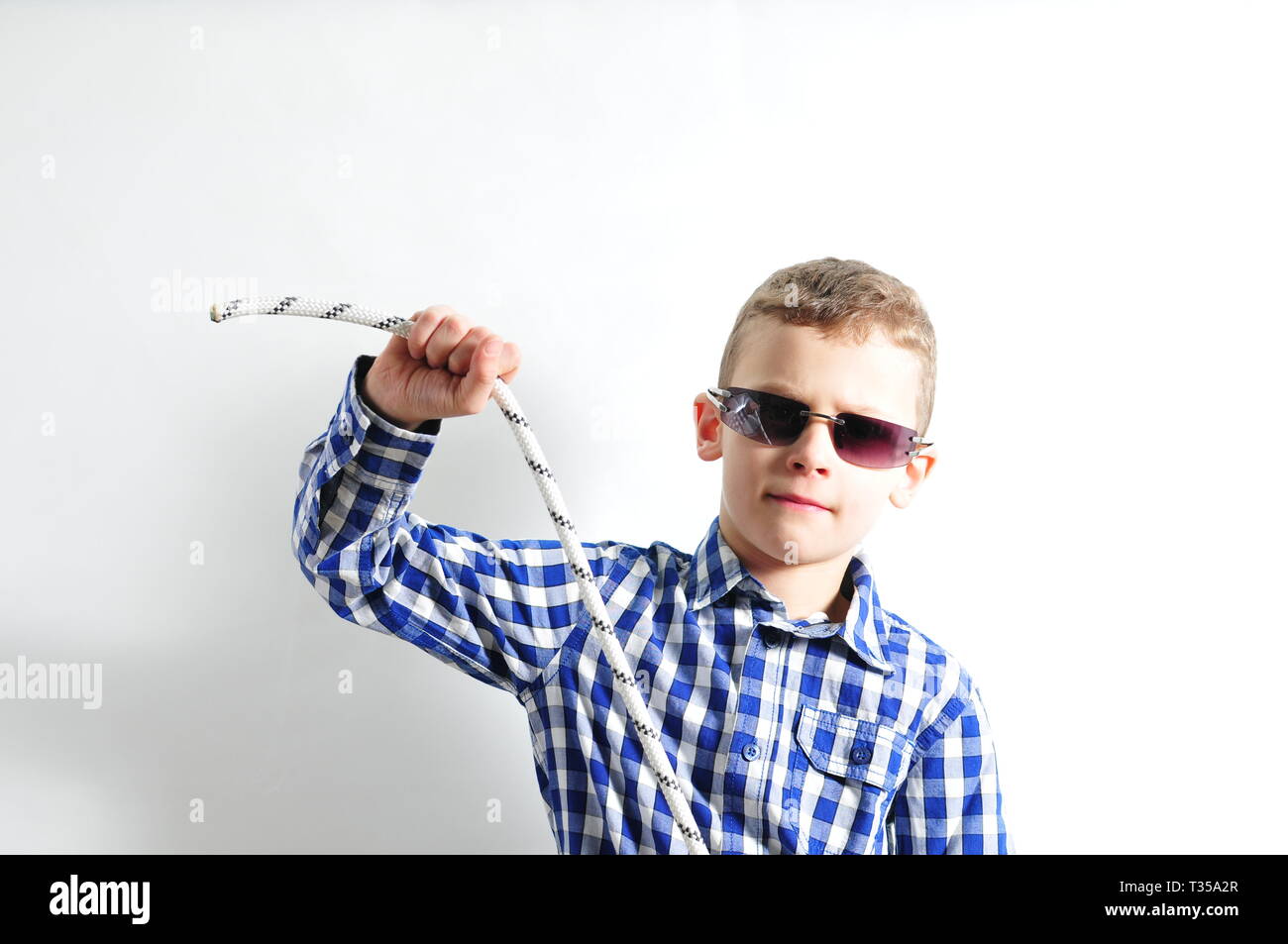Ragazzo con occhiali da sole e controllato shirt tenendo una corda nelle  sue mani Foto stock - Alamy
