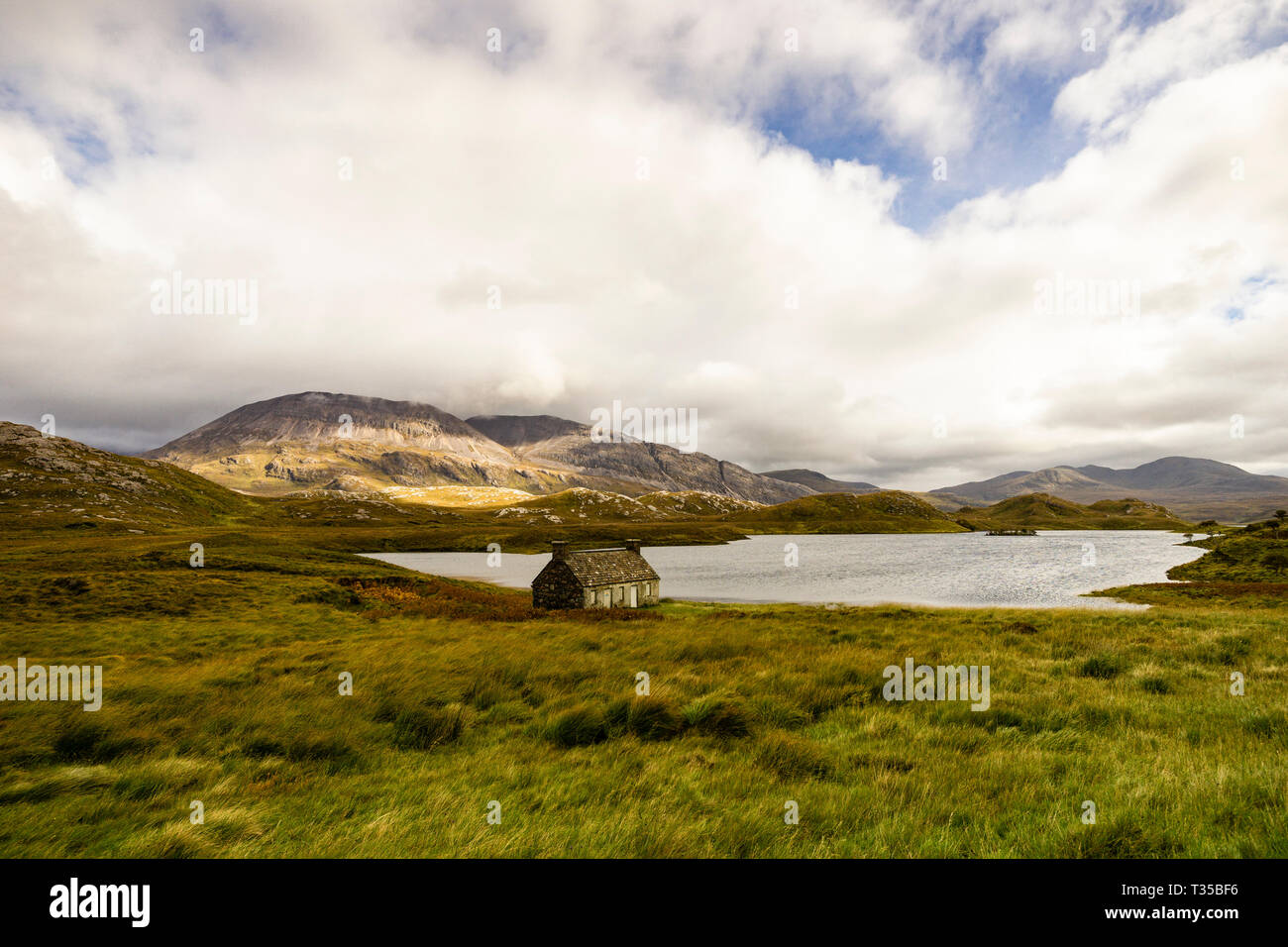 Ben Arkle sullo sfondo di un abbandonato croft casa sulla riva settentrionale del Loch stack su un giorno nuvoloso in autunno. Foto Stock