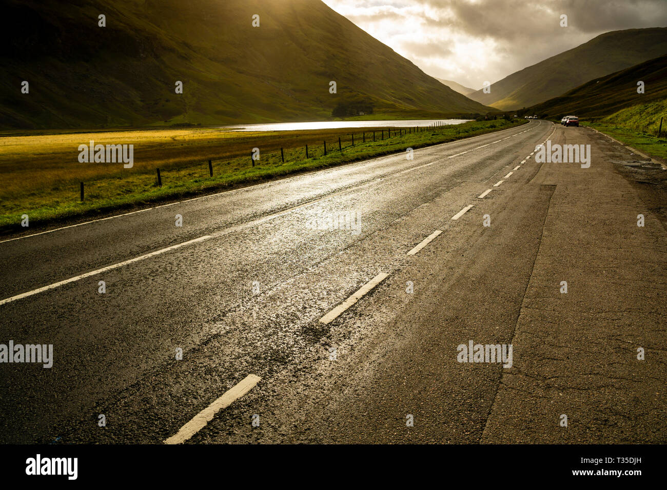 Sole che filtra attraverso le nubi per illuminare selettivamente porzioni di valle di Glencoe, Scozia. Foto Stock