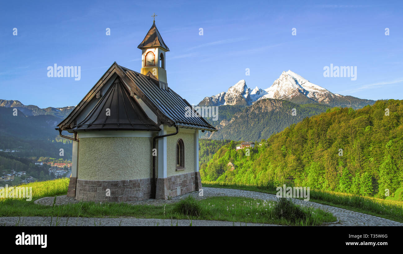 Panoramica vista molla accanto a Berchtesgaden township con il monte Watzmann e tradizionale cappella Kirchleitn Foto Stock