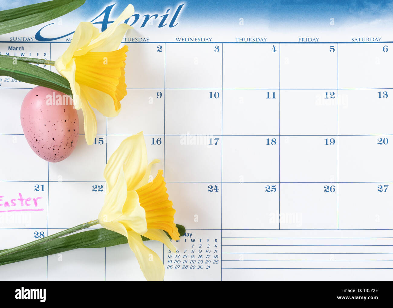 Vacanze di Pasqua segnata sul calendario con Yellow Daffodils e uova colorate Foto Stock