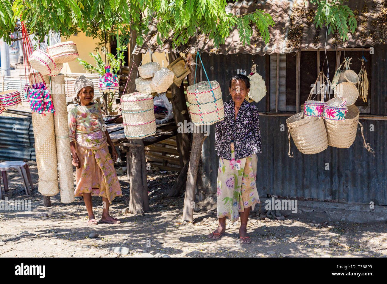Dili, Timor Est - 11 Ago, 2015: due anziani locali nativi di Timor Est le donne, street vending tradizionali canestri di vimini appesi a funi, in un stagno h Foto Stock