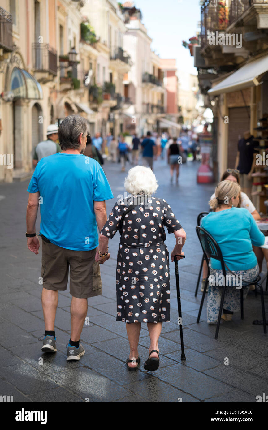 Due generazioni di fare la passeggiata, passeggiando in Corso Umberto I nella città di Taormina, Sicilia Est, Italia Foto Stock