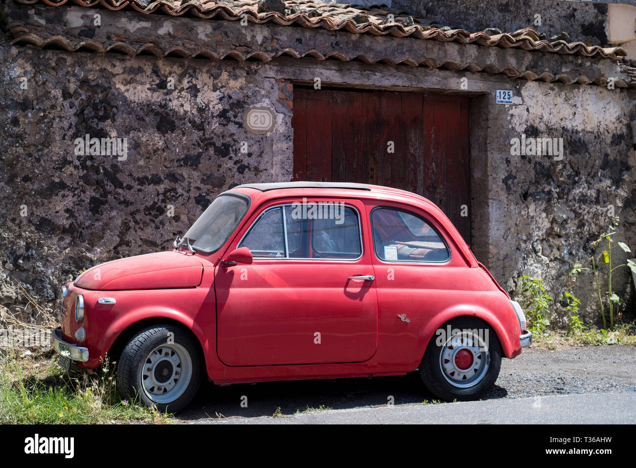 Colore rosso vivo polveroso vecchio 500 Fiat Cinquecento versione precoce - tipica italiana della piccola city car in Sicilia, Italia Foto Stock