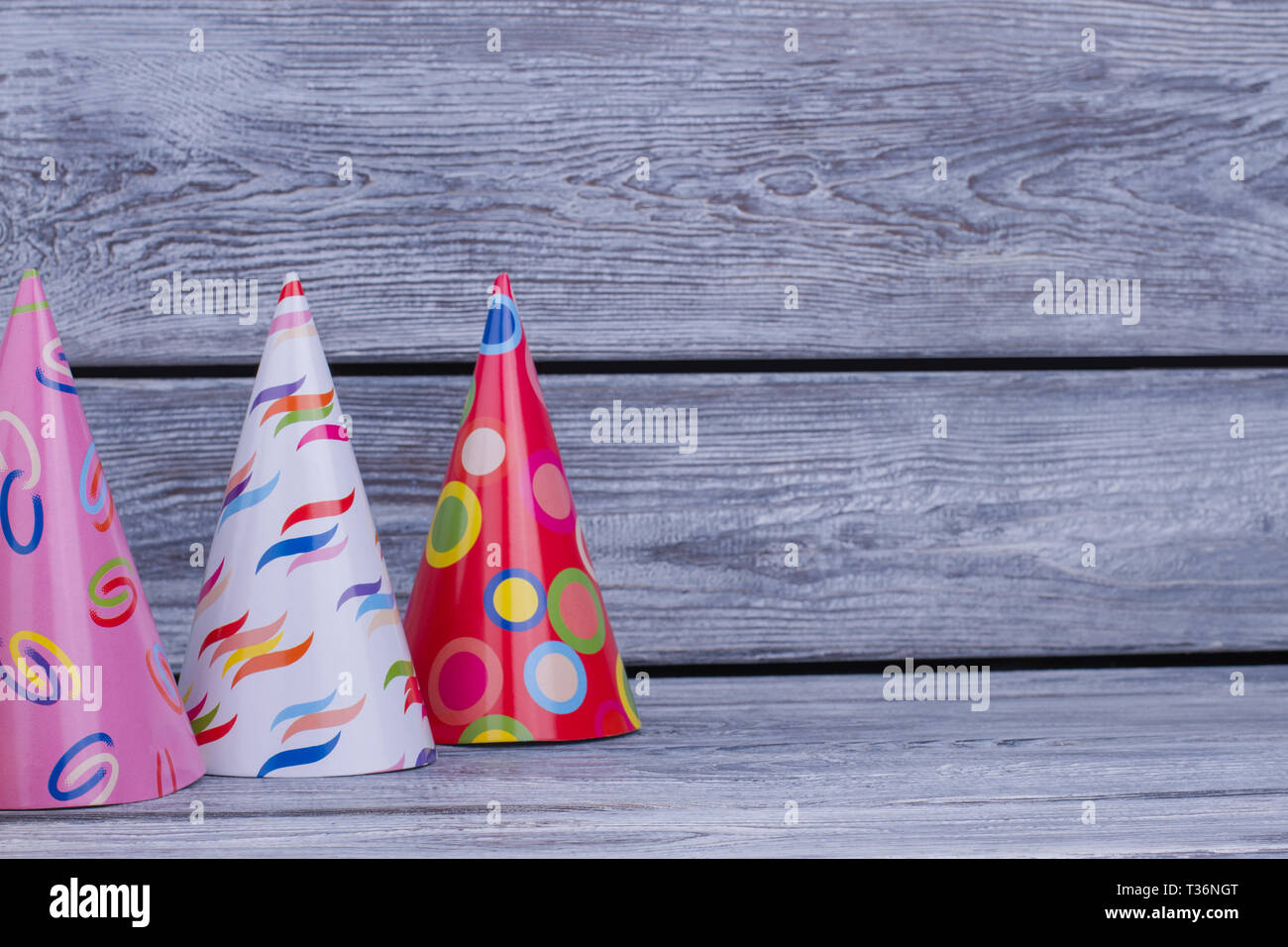 Divertente per i cappelli di carta per la festa di compleanno. Cono di  cartone cappelli su rustiche tavole in legno con lo spazio di testo Foto  stock - Alamy