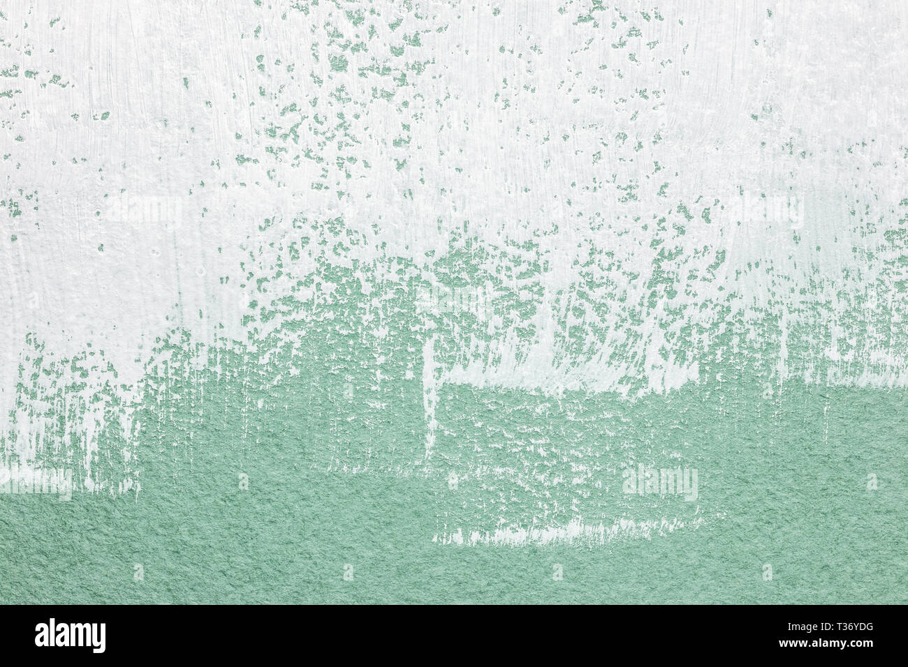 La vernice bianca pennellate su textured verde chiaro sfondo della carta Foto Stock