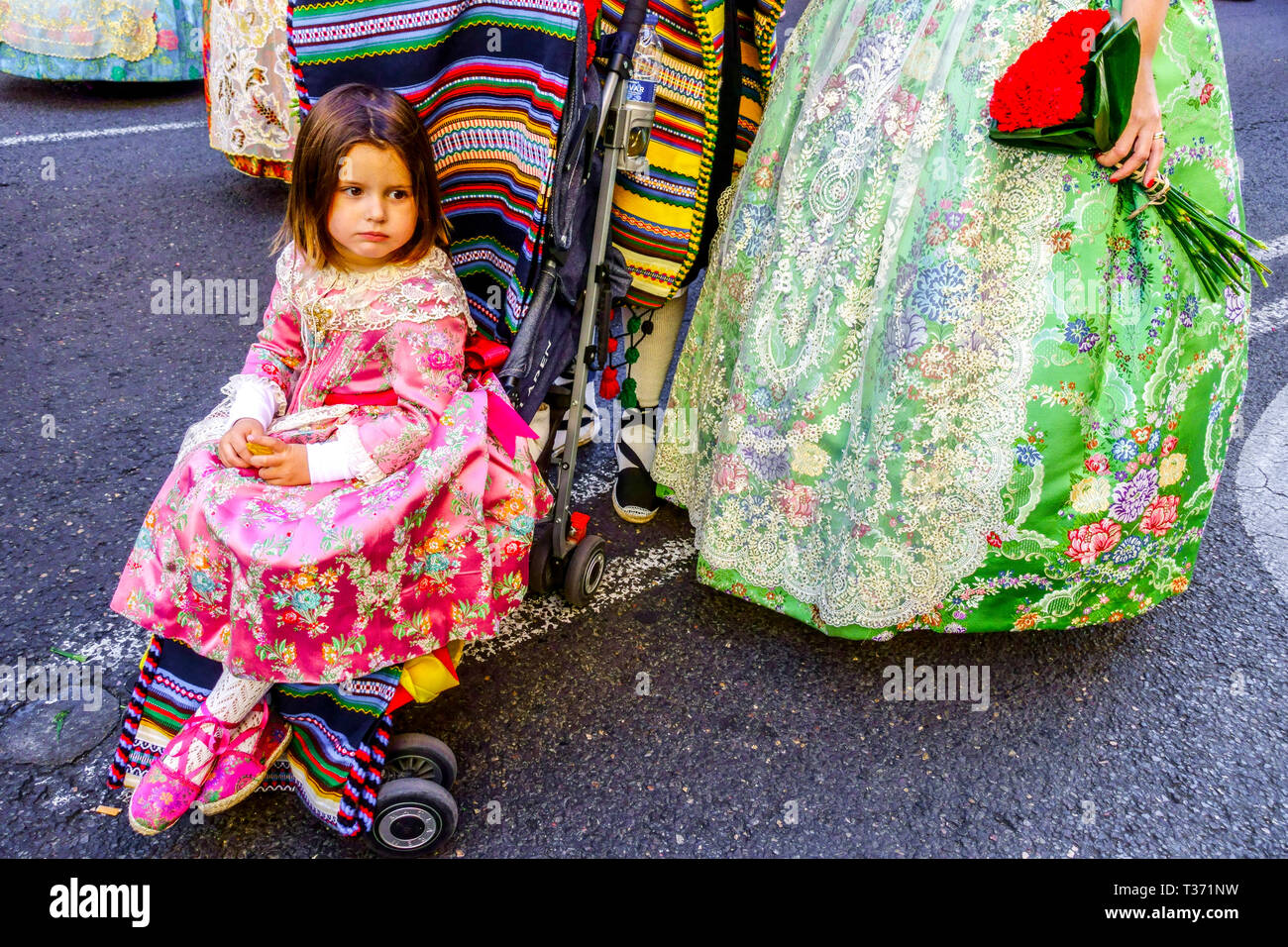 Valencia Fallas festival, bambino in pram con la famiglia in costume tradizionale marching attraverso la città, Las Fallas Spagna Europa Foto Stock