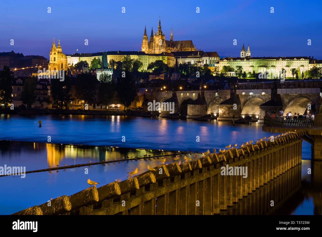 Città di Praga in serata in Cechia (Repubblica Ceca), illuminato il Castello, vista sul fiume Vltava. Foto Stock