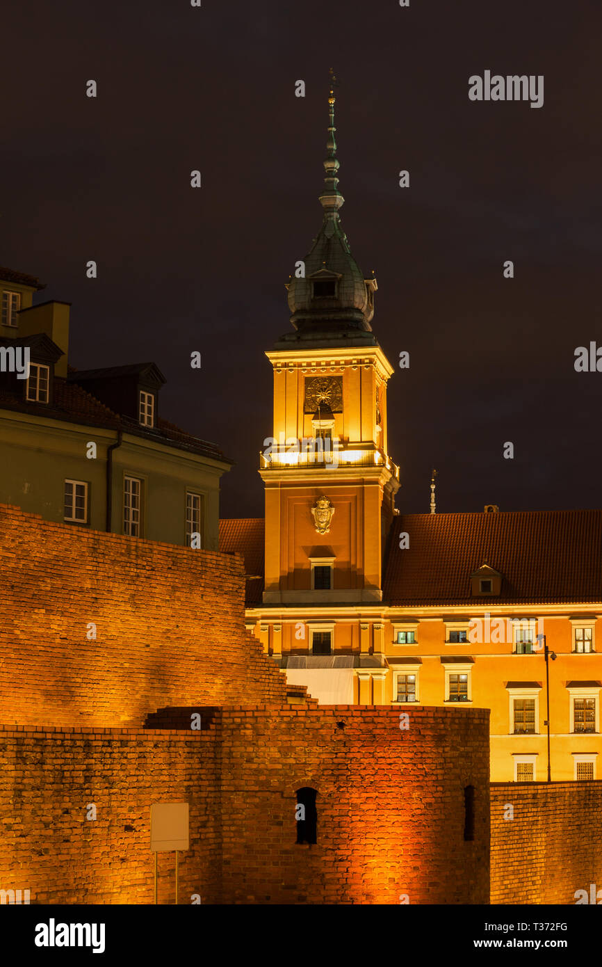 Il castello reale e la parete della città illuminata di notte nella Città Vecchia di Varsavia in Polonia Foto Stock