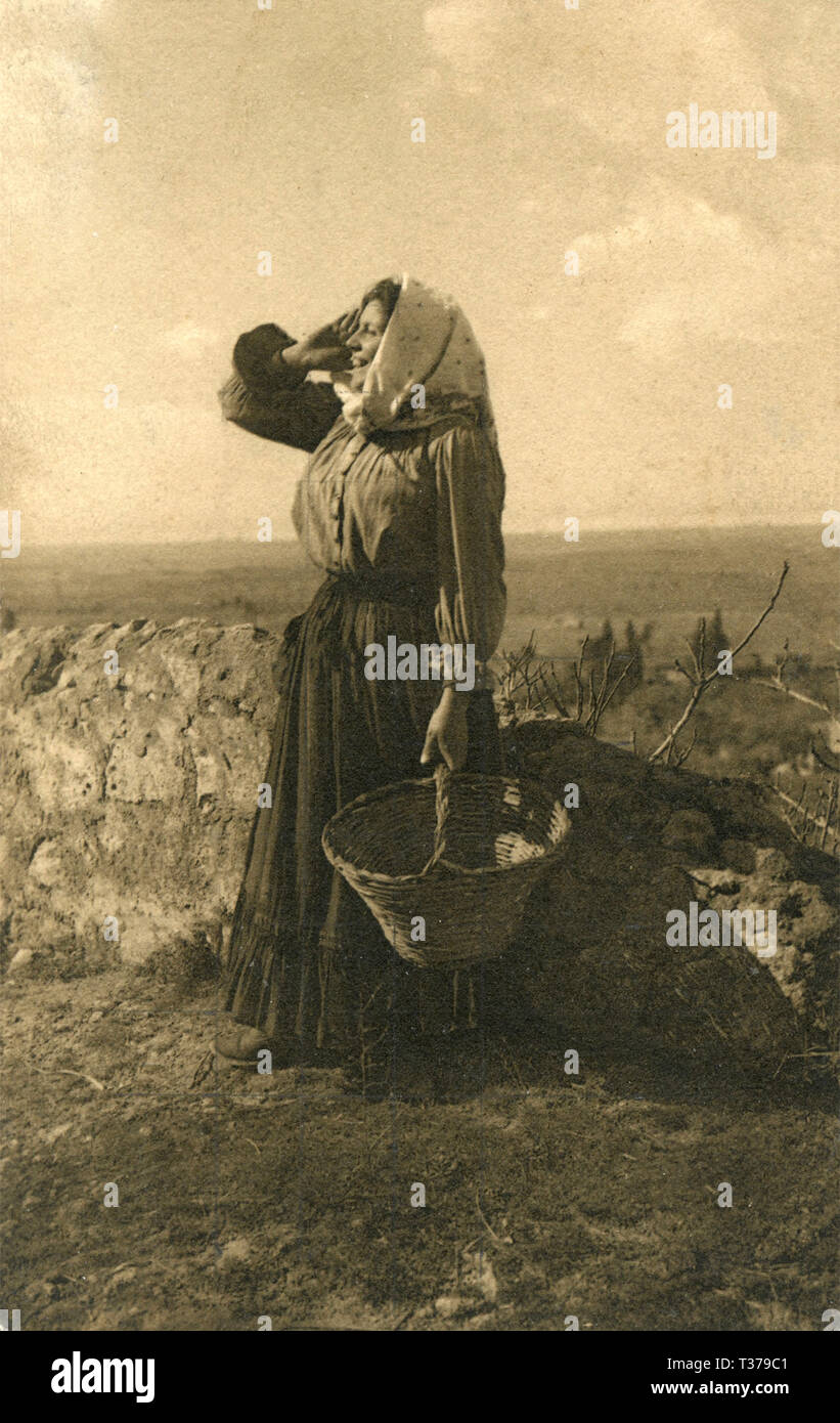Donna agricoltore chiamare attraverso i campi, Italia 1930 Foto Stock