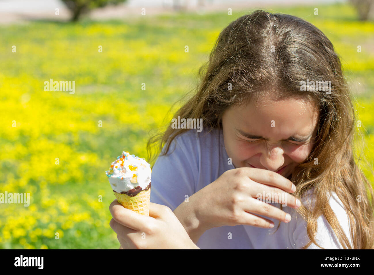 Insoddisfatto infelice ragazza teen mangia insapore gelato in cono di cialda in estate Foto Stock