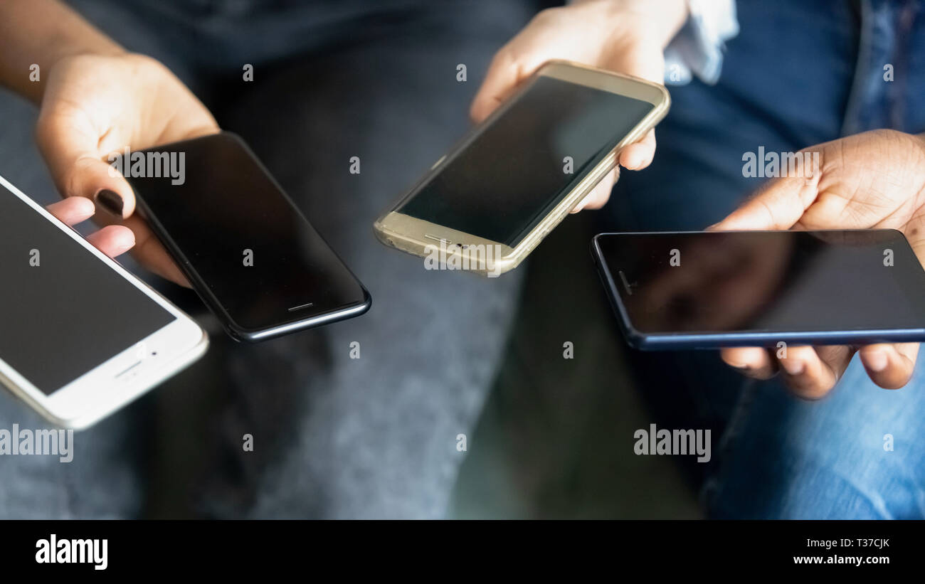 Maschio e femmina tenendo le mani telefoni, vista ravvicinata Foto Stock