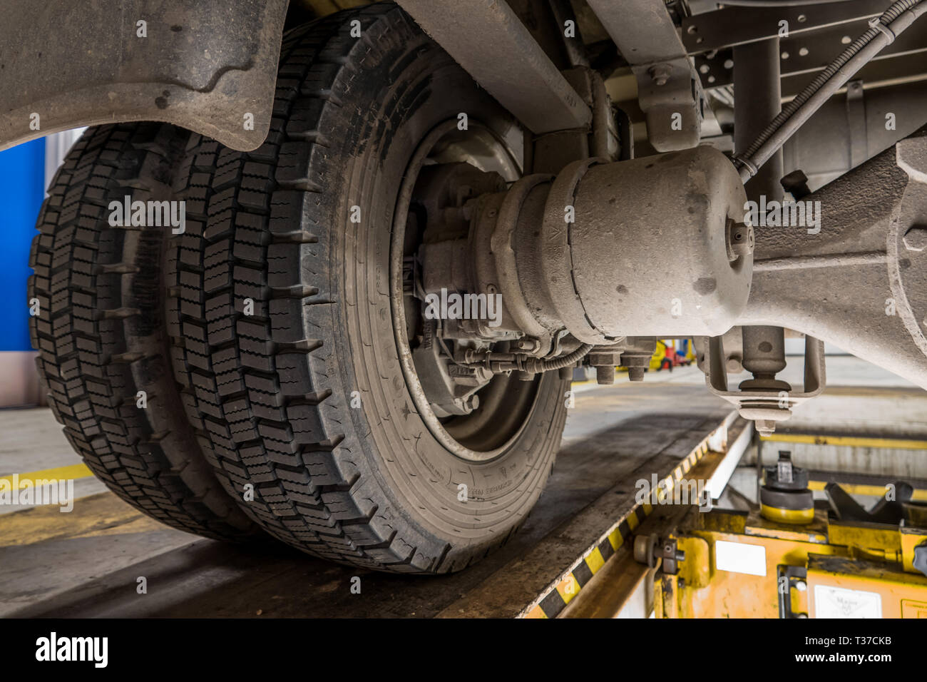 Vista di freni a disco e sospensione su un piccolo camion dalla fossa di manutenzione. Foto Stock