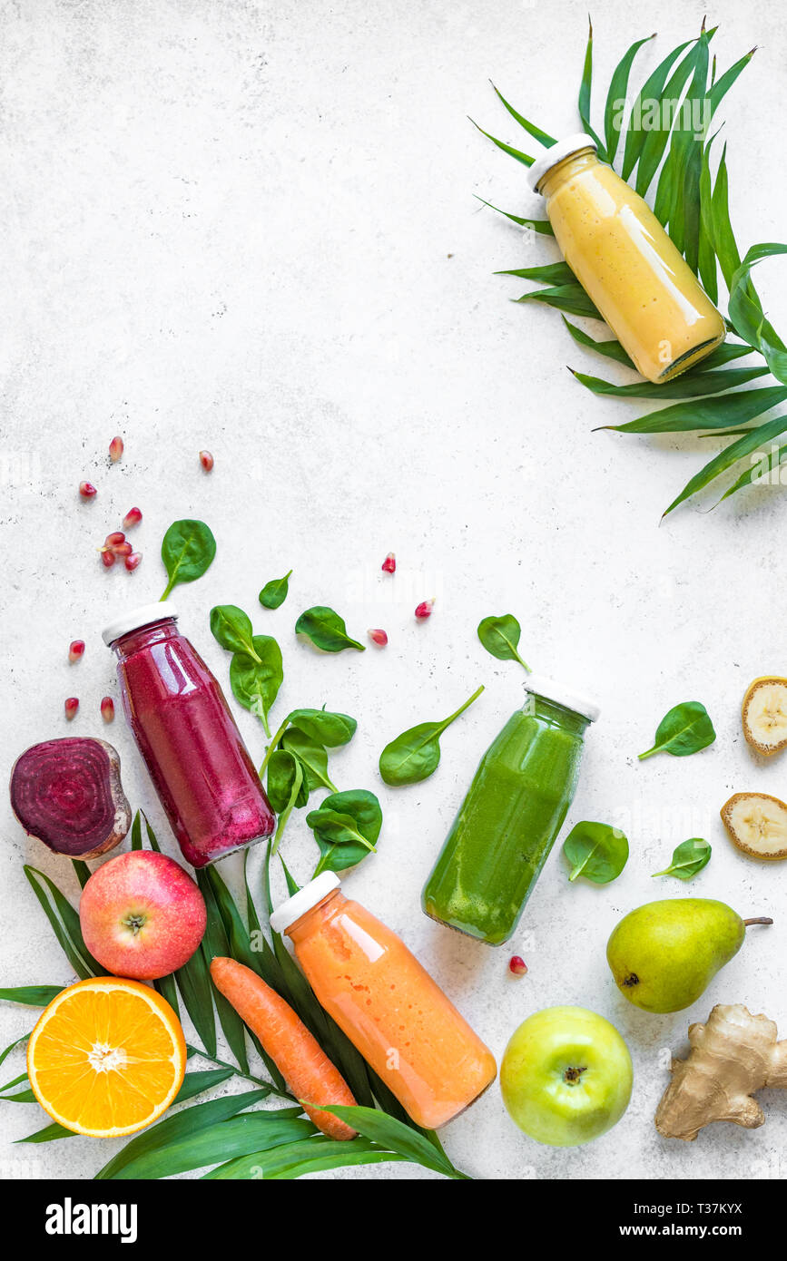 Detox cibo e pulire il concetto di mangiare. Vari i frullati o succhi di frutta in bottiglie e ingredienti su bianco, vista dall'alto, copia dello spazio. Foto Stock