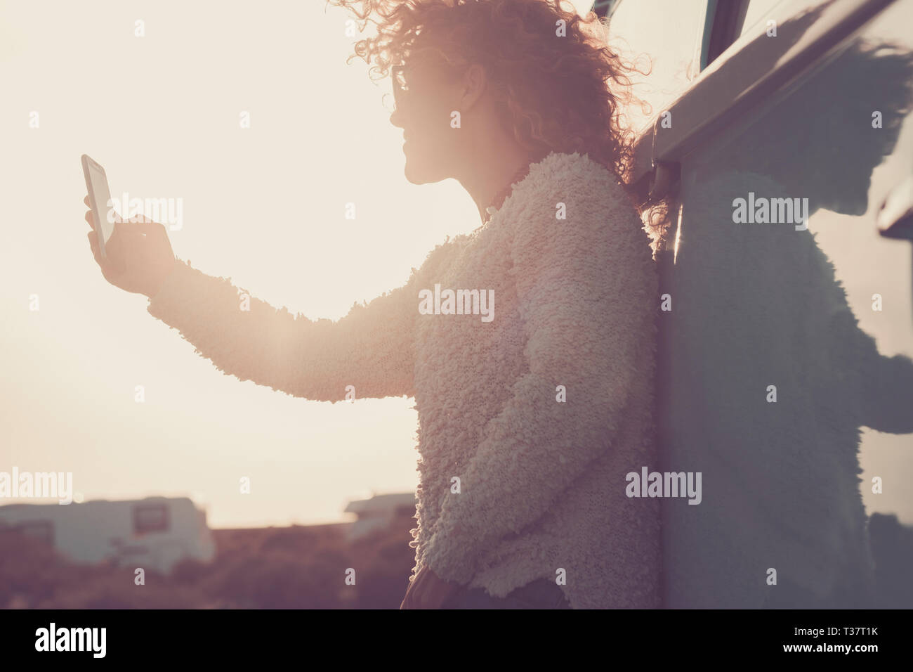 Le persone in vacanza withtechnology vintage e lo stile di vita e wanderlust - bella donna prendendo selfie foto con smart phone - luce del sole al tramonto in b Foto Stock