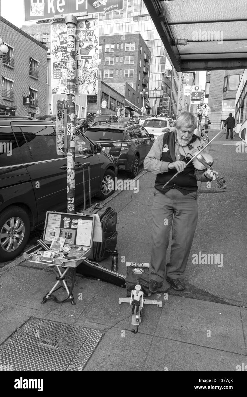 Seattle, Washington - 2018-12-30 - il musicista suona il violino sulla strada di fronte il Mercato di Pike Place raccogliere i soldi in una valigia Foto Stock