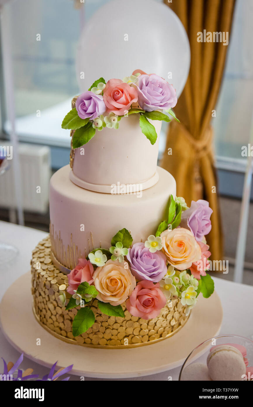 Grande multilivello dolce torta nuziale decorata con fiori. Concetto di candy bar sulla parte.
