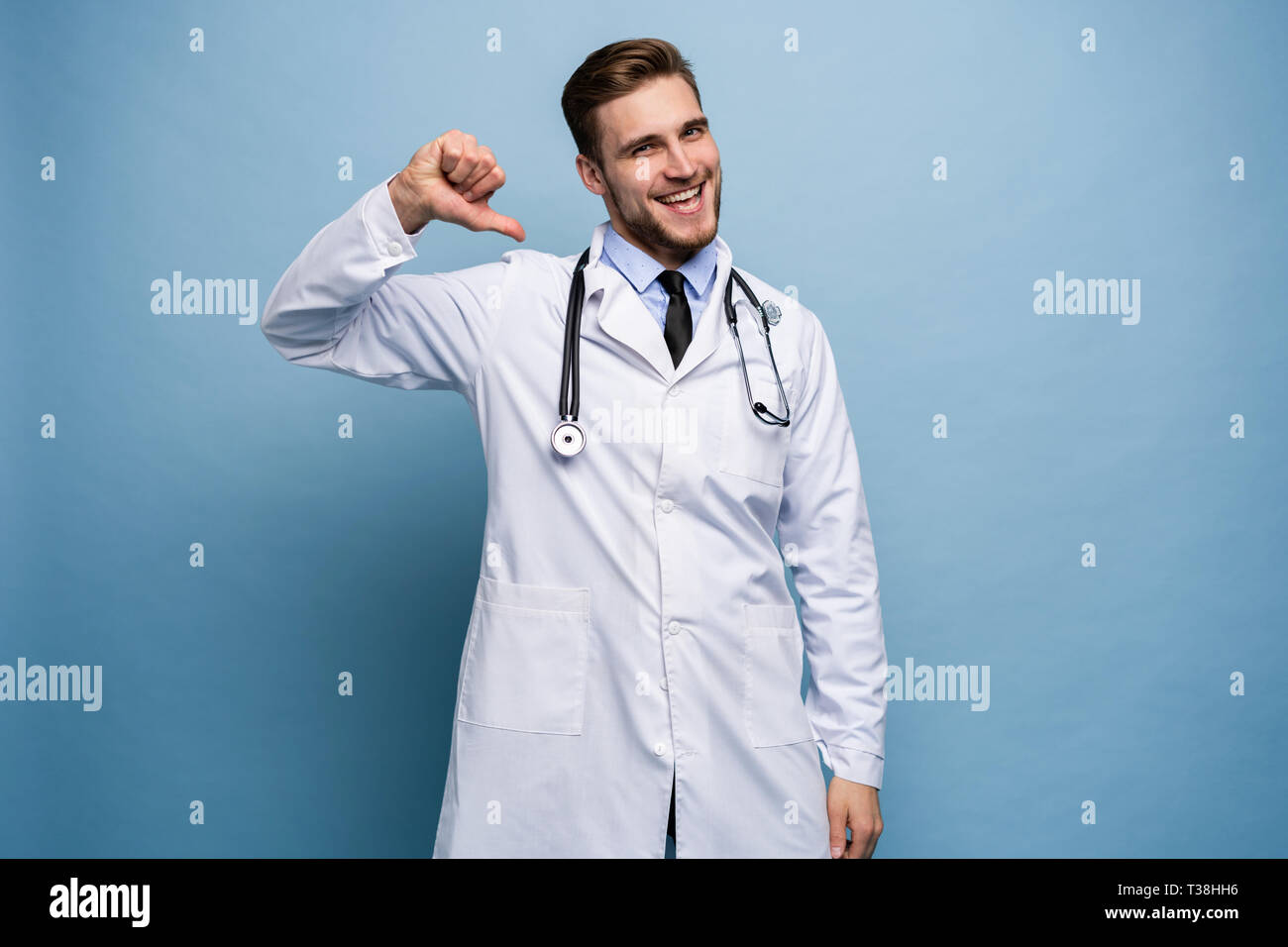 Medico chirurgo uomo orgoglioso e auto-soddisfatta in ama te stesso concetto isolato su luce blu. Foto Stock