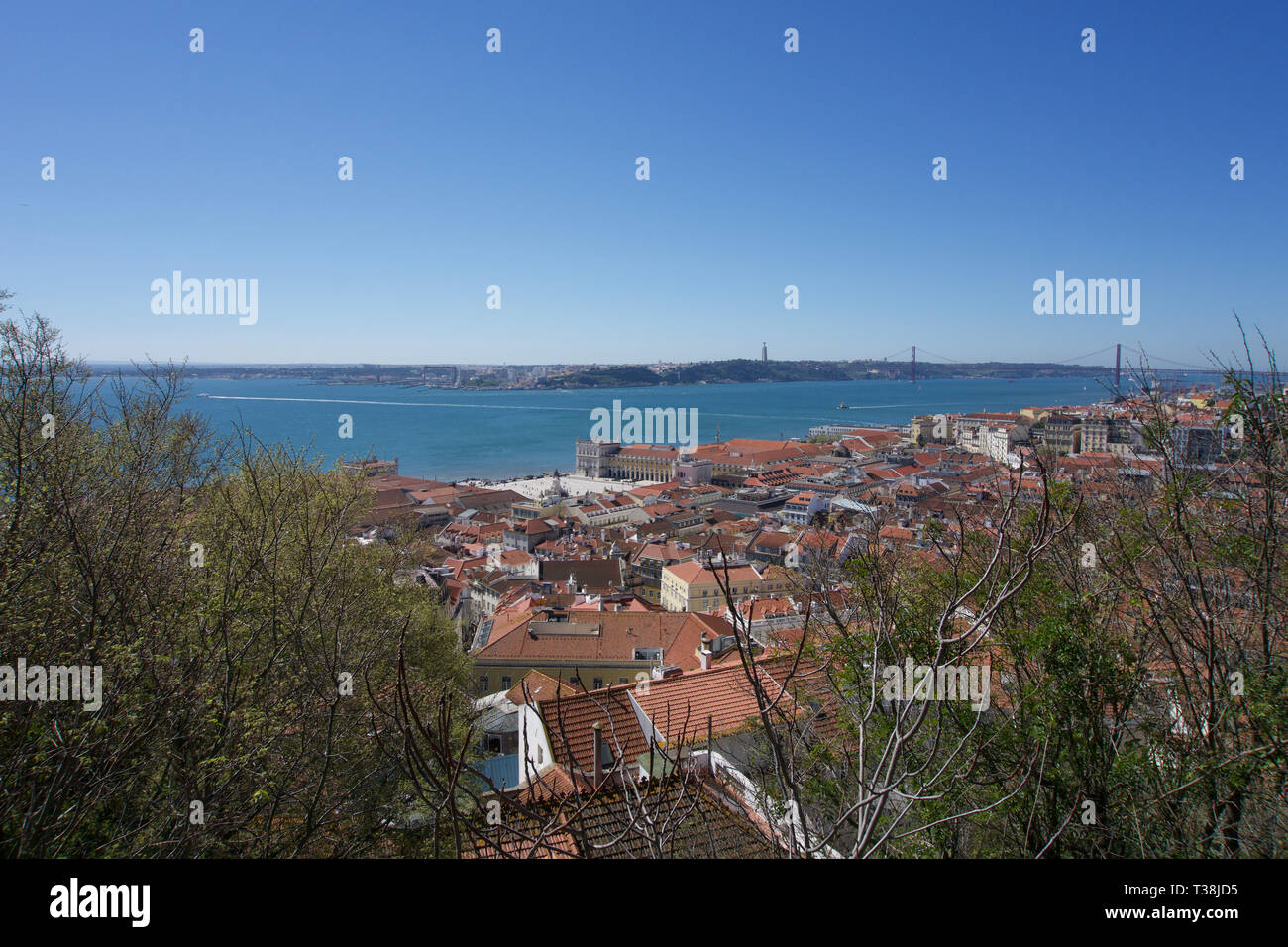 Vista dei tetti, sospensione ponte sul fiume e piazza nel centro di Lisbona da Castelo da Sao Jorge sotto un cielo blu chiaro con spazio di copia Foto Stock
