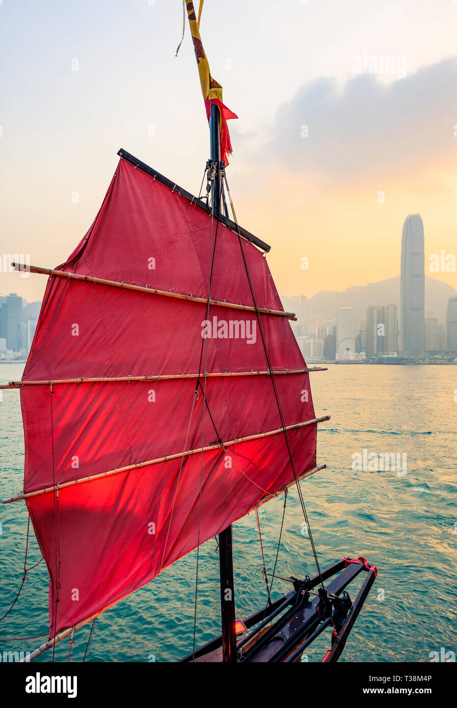 Sail dettaglio dell'Aqualuna junk imbarcazione turistica al tramonto con l'Isola di Hong Kong skyline dietro, del porto di Victoria e di Hong Kong Foto Stock