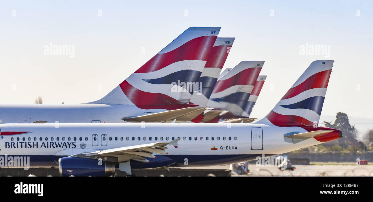 Londra, Inghilterra - Marzo 2019: Airbus A320 di breve raggio aereo di linea di rullaggio passato le alette di coda della compagnia aerea jumbo jet Boeing 747 schierate a Londra Hea Foto Stock