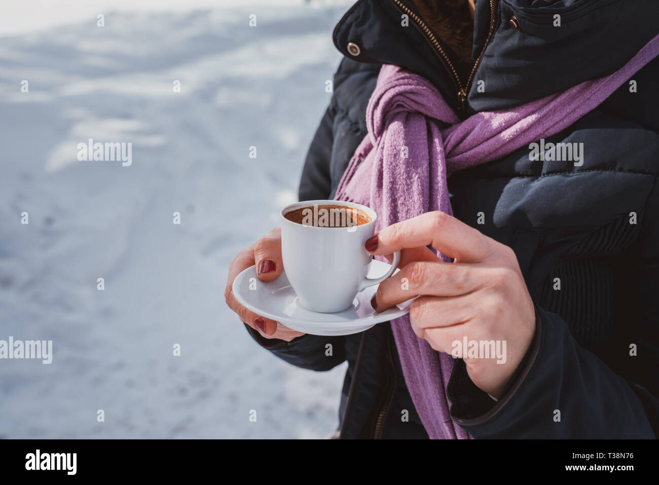 Mani femminili coppa di ritegno con caffè caldo in tazza bianca. Foto Stock