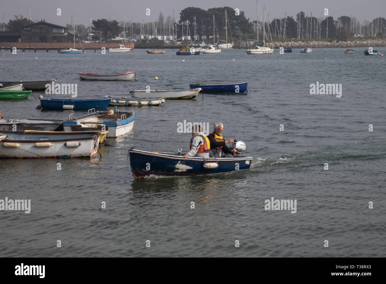 Coppia in pensione sulla barca di legno con motore fuoribordo voce in porto Foto Stock