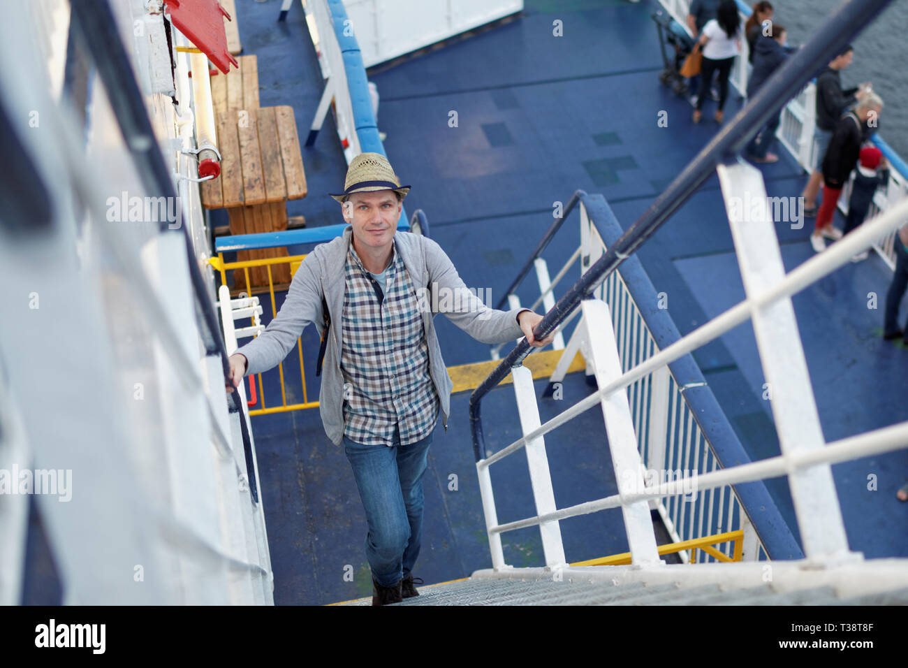 Felice uomo salire sul ponte della nave da crociera Foto Stock