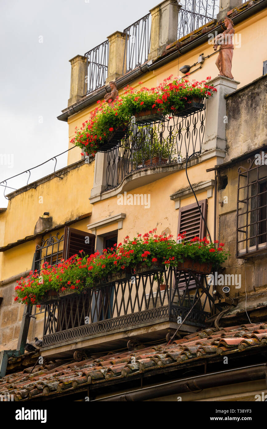Edificio italiano con balcone in ferro adirato decorativo, porte finestre e  statue in terracotta vicino al Ponte Vecchio a Firenze Foto stock - Alamy